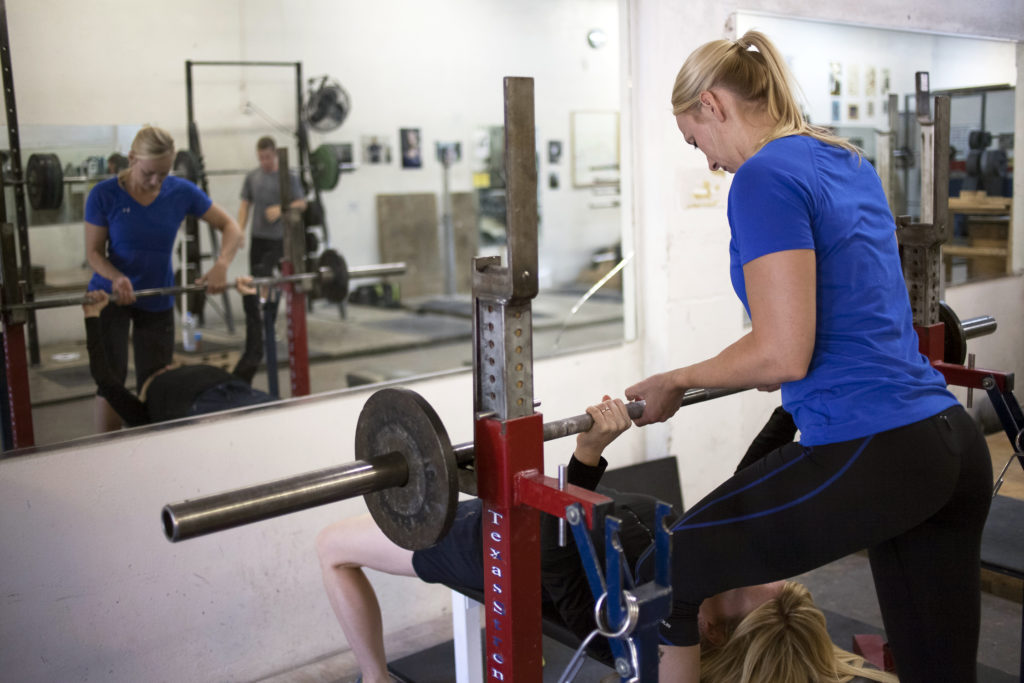 Kathryn Alexander of Alexander Training spots a client on the bench press.