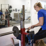 Kathryn Alexander personal trainer spots a client during a bench press